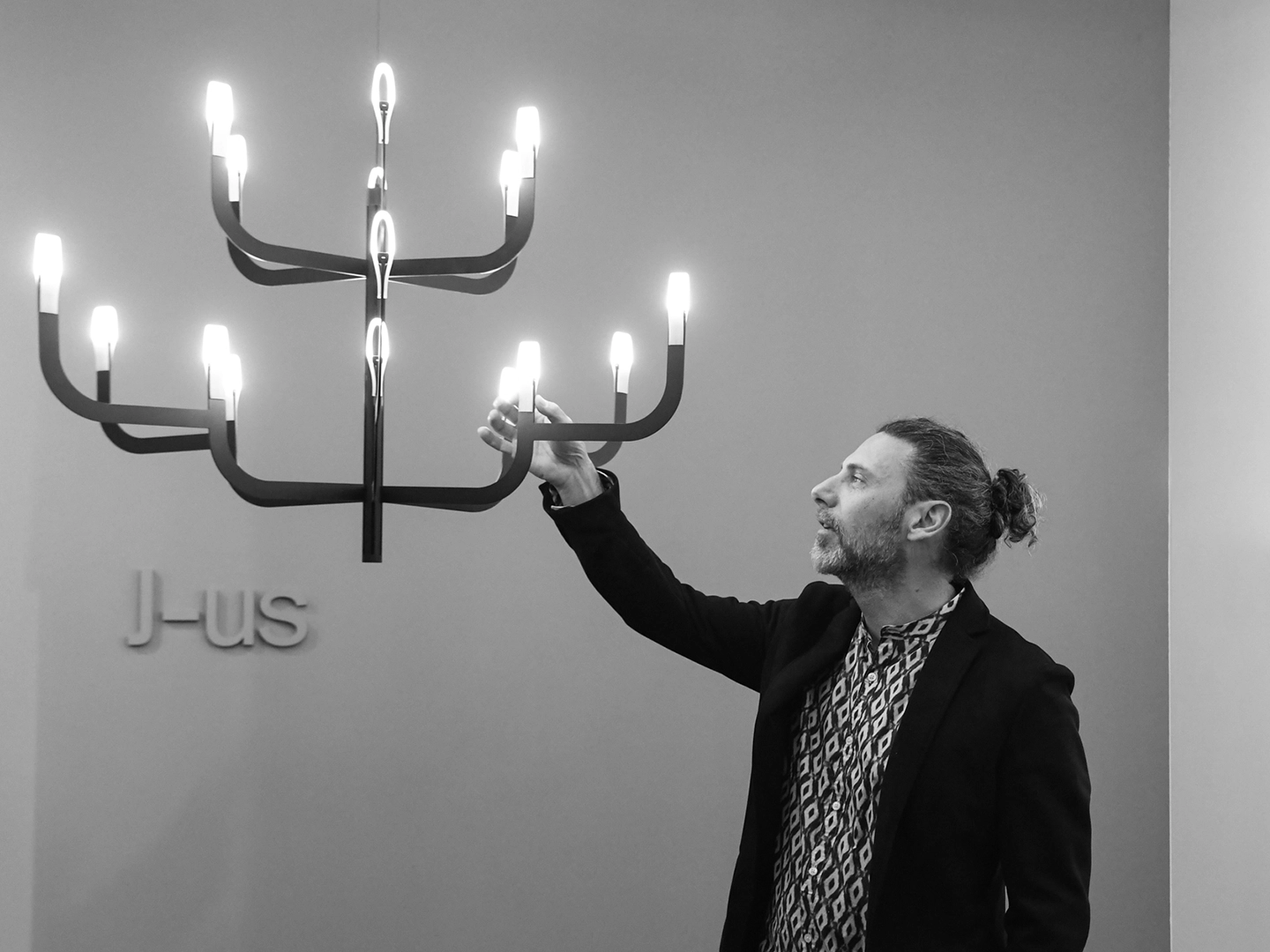 Alessandro Zambelli, designer di J-us, fotografato insieme alla lampada